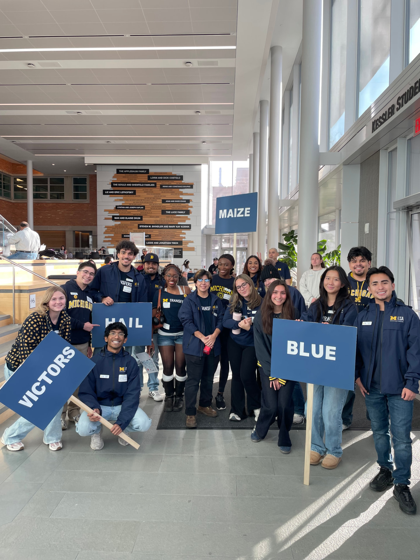 Sky with the transfer student welcome team holding Maize, Blue, Hail, and Victors signs